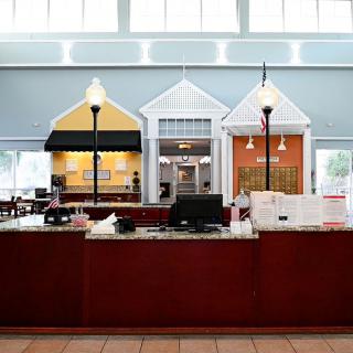 A reception desk inside a library with colorful, house-like structures and lantern-style lights.