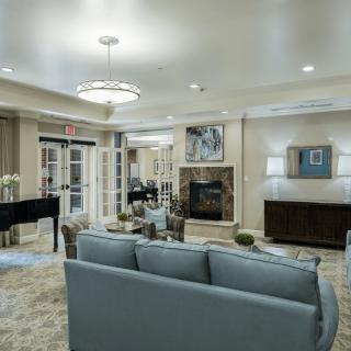 A modern living room with a comfortable sofa, elegant chandelier, and a fireplace.