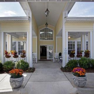 An inviting entrance featuring landscaped flowers and elegant columns.