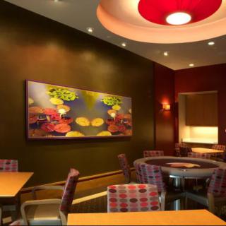 A modern restaurant interior featuring colorful wall art and cozy seating arrangements.