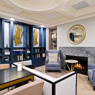 A stylish living room with modern decor, featuring a cozy fireplace, elegant artwork, and comfortable seating.