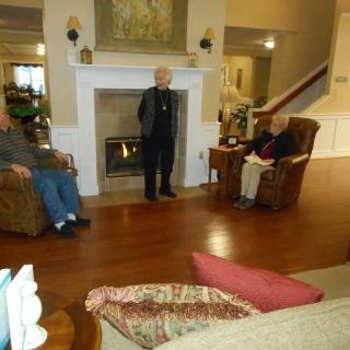 A cozy living room setting with people engaged in conversation near a fireplace.
