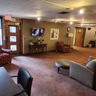 A cozy lobby featuring comfortable seating arrangements and a television.