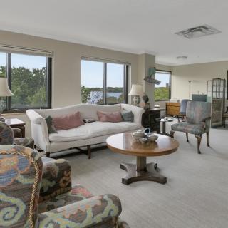 A well-lit living room with a comfortable sofa, coffee table, and large windows.