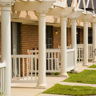 A row of residential buildings featuring white columns and porches.