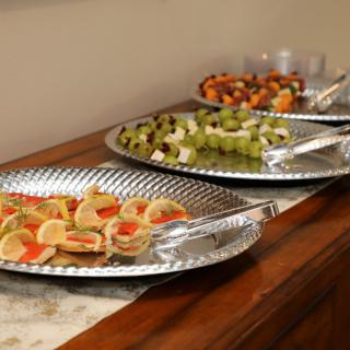 A buffet display featuring assorted appetizers and fruit platters.