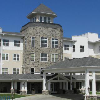 A three-story building with a stone facade and covered entrance.