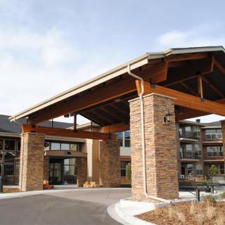 A modern building entrance with stone pillars and a covered entryway.