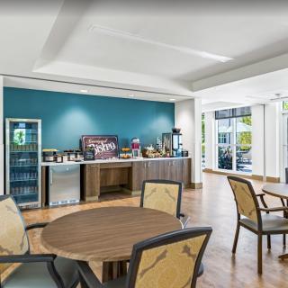 A modern cafe interior with a beverage station and seating area.