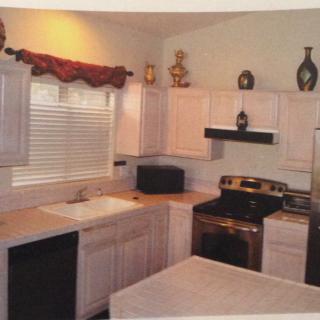 A cozy kitchen interior featuring white cabinets, modern appliances, and decorative accents.
