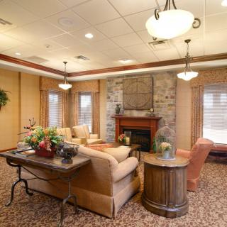 A cozy living room with a fireplace, comfortable seating, and elegant lighting.