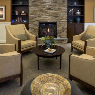 A cozy living room with a stone fireplace and comfortable seating arrangement.