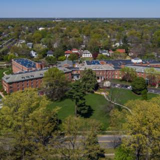 A scenic aerial view of a college campus surrounded by lush greenery.
