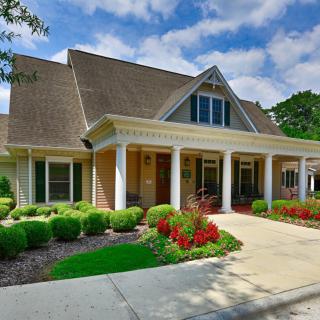A charming suburban house with a landscaped front yard and driveway.