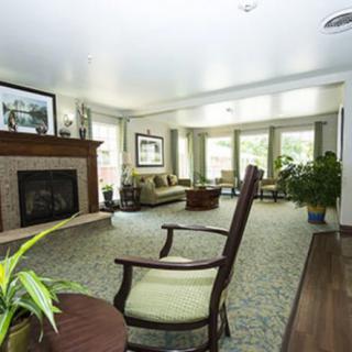 A spacious living room with a fireplace, comfortable seating, and large windows letting in natural light.