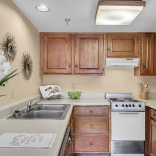 A cozy kitchen with wooden cabinets and a compact stove.