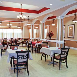 A well-decorated restaurant dining area with neatly arranged tables and chandeliers.
