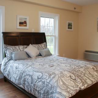 A cozy bedroom with a large bed, soft lighting, and decorative elements.