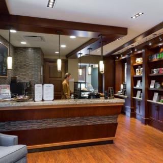 A modern hotel reception area with wooden decor and stylish lighting.