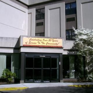 The entrance of a building with a sign celebrating years of service to the community.
