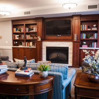 A cozy living room featuring a fireplace, built-in bookshelves, and comfortable seating.
