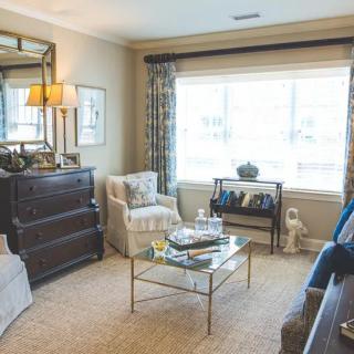 A cozy living room with elegant furniture and ample natural light from a large window.