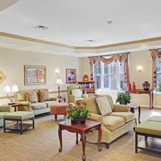 A spacious and elegantly decorated living room with various seating arrangements and warm lighting.