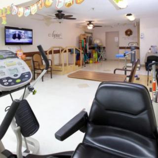 A rehabilitation room equipped with exercise machines and a television.