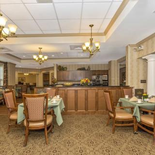 A cozy dining area with elegant chandeliers and neatly arranged tables.