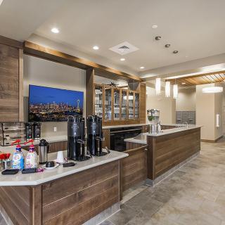 A modern cafe with a well-lit coffee station and wooden accents.