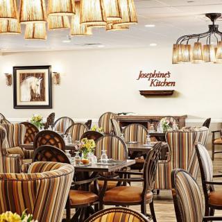 A well-lit restaurant dining area with striped chairs and elegant lighting fixtures.