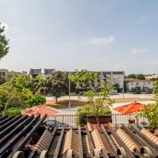 A sunny day view from a rooftop overlooking buildings and trees.