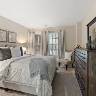 A cozy and elegantly designed bedroom featuring neutral tones and stylish furniture.