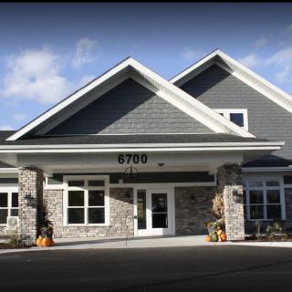 A modern residential building with a prominent entrance and large windows.