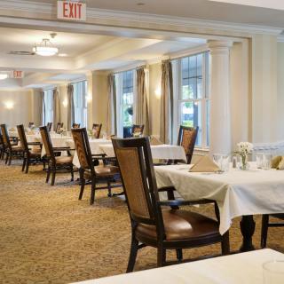 Elegant dining room with neatly set tables and chairs.