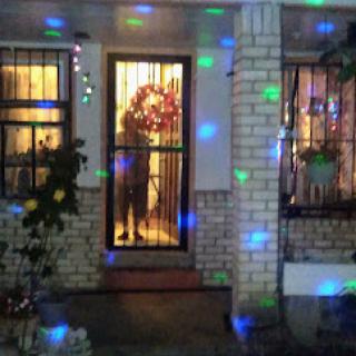 A beautifully decorated doorway illuminated with colorful lights during the holiday season.