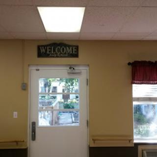 A welcoming entrance featuring a door with a welcome sign and natural light from the window.