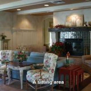 A cozy sitting area with floral chairs and a fireplace.