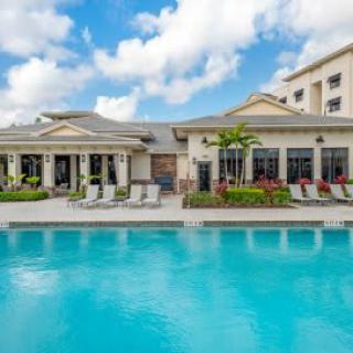 A serene outdoor pool area at a resort with a modern building in the background.