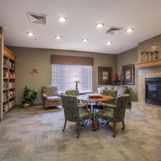 A cozy living room with a fireplace, bookshelves, and comfortable seating.