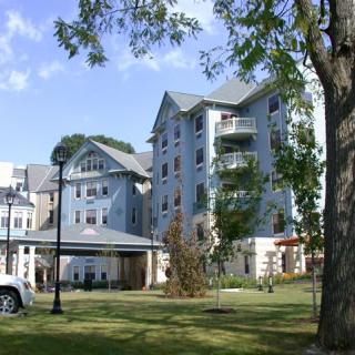 A residential apartment building surrounded by trees and greenery.
