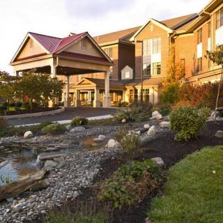 A scenic view of a hotel entrance surrounded by well-maintained gardens.