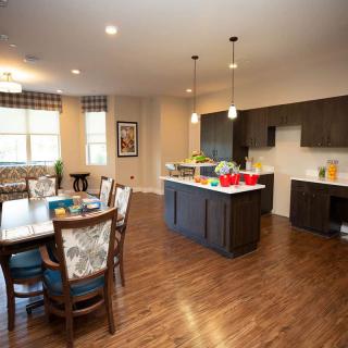 A modern kitchen and dining area with wood flooring and contemporary decor.