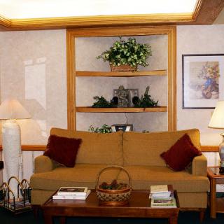 A cozy living room setup featuring a comfortable sofa, decorative shelves, and warm lighting.