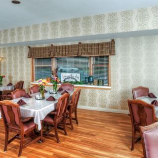 A cozy dining room with elegant furniture and hardwood flooring.