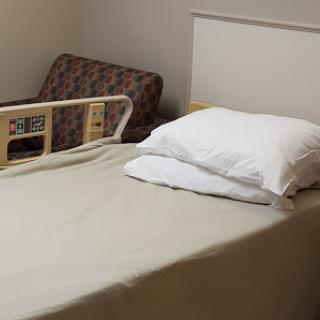 A tidy hospital bed prepared for a patient in a healthcare setting.
