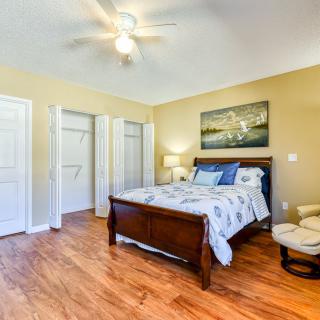 A well-lit bedroom with a wooden bed, matching furniture, and elegant decor.