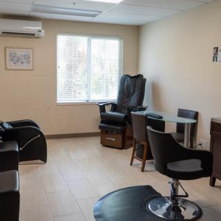 A cozy salon interior with chairs and tables near a window.