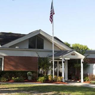 A residential-style building with a flagpole and well-maintained landscaping.