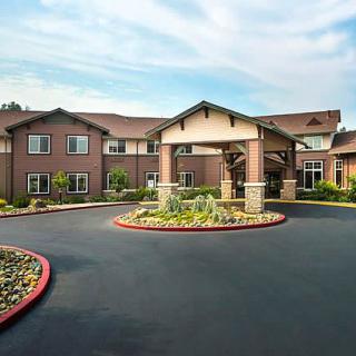 A residential building with a landscaped entrance and circular driveway.